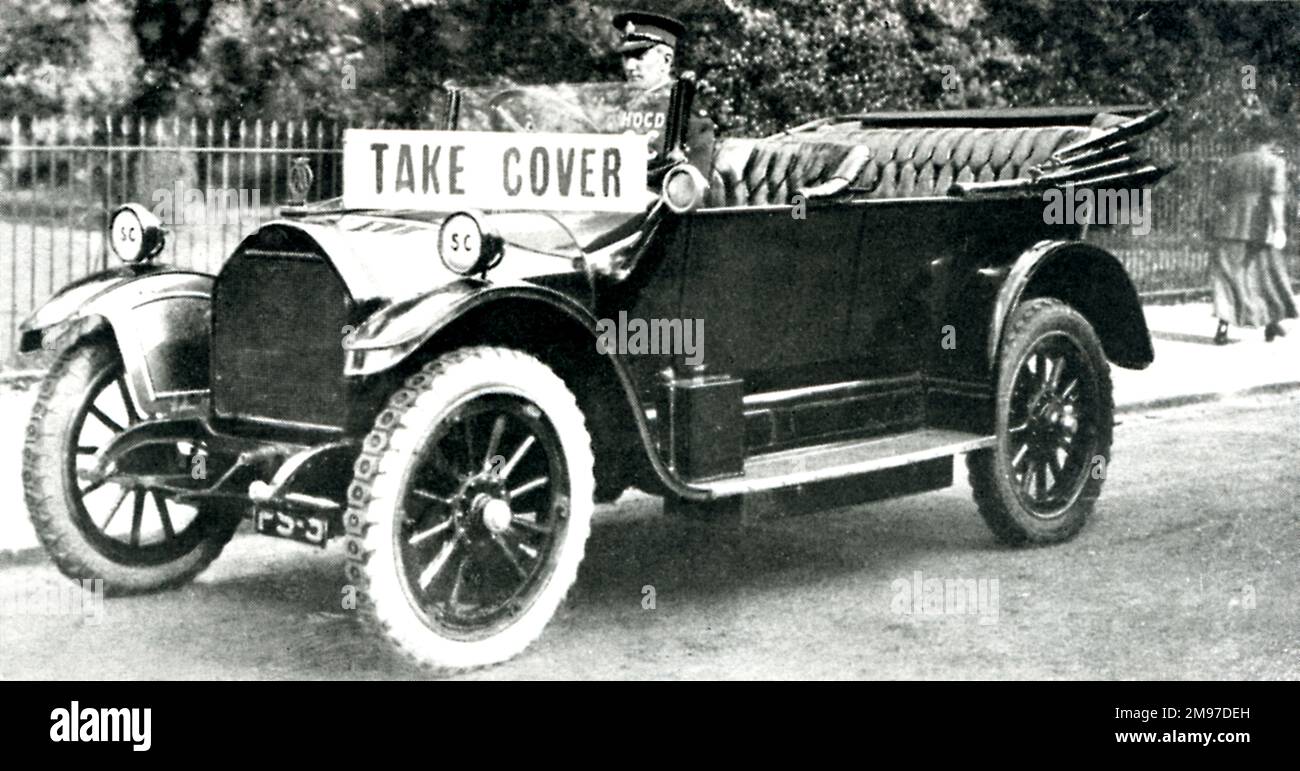 Un'auto con il cartello "Take Cover" che avverte il pubblico di un imminente attacco di RAID aereo. Foto Stock