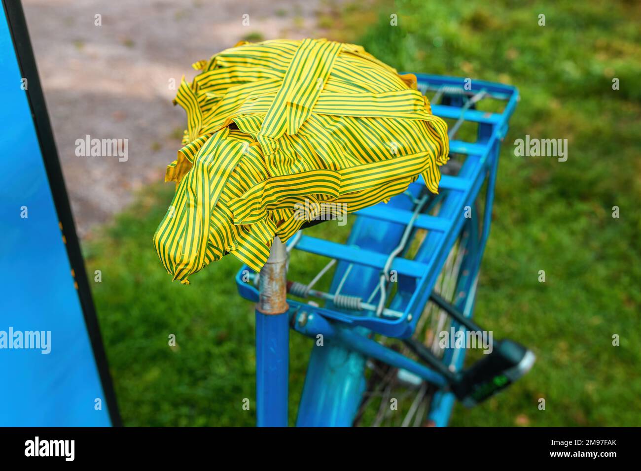 Sedile della bicicletta danneggiato con nastro isolante verde e giallo, messa a fuoco selettiva Foto Stock