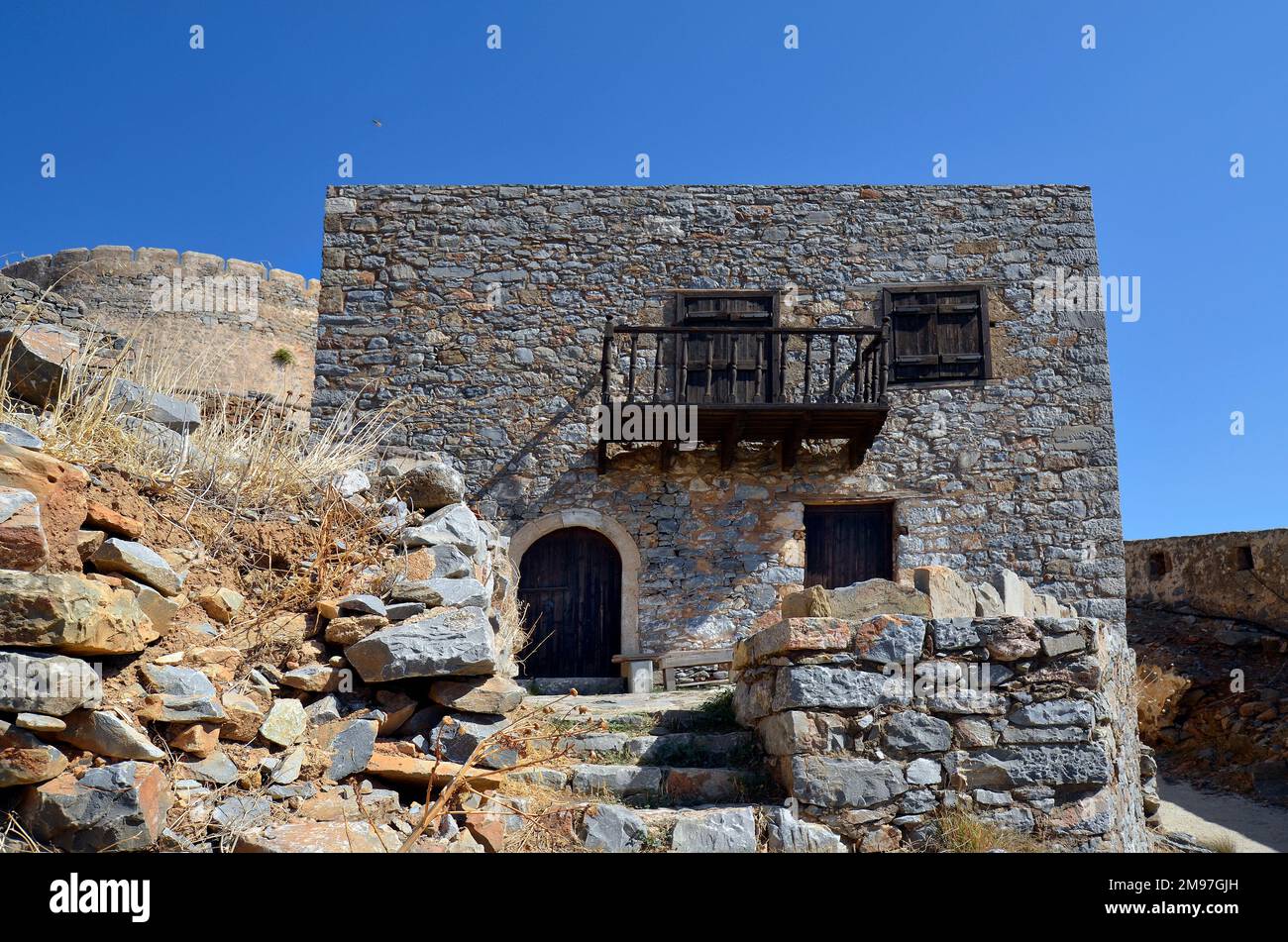 Grecia, Creta, casa con balcone costruito in pietra nella vecchia Fortezza Veneziana Spinalonga, fino al 1957 utilizzato come stazione lebbroso, ora un popolare turista destinia Foto Stock