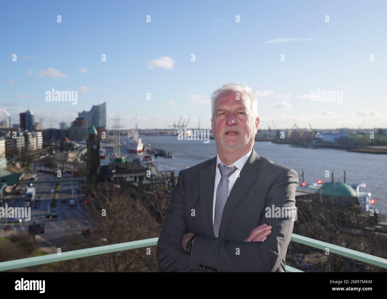 17 gennaio 2023, Amburgo: Bernd Brügge, capo del Dipartimento di Oceanografia e vicepresidente della BSH, si trova su un balcone dopo la conferenza stampa annuale dell'Agenzia federale marittima e idrografica (BSH). Il Landungsbrücken, il Überseebrücke e l'Elbphilharmonie sono visibili sullo sfondo. La BSH non vede alcuna possibilità di accelerare il processo di approvazione del dumping del limo Elbe nella zona economica esclusiva. Amburgo è sotto una certa pressione quando si tratta di smaltimento del limo, perché l'accordo sullo scarico del limo in mare marker E3 vicino a Helgoland è limitato nel tempo e la ne Foto Stock
