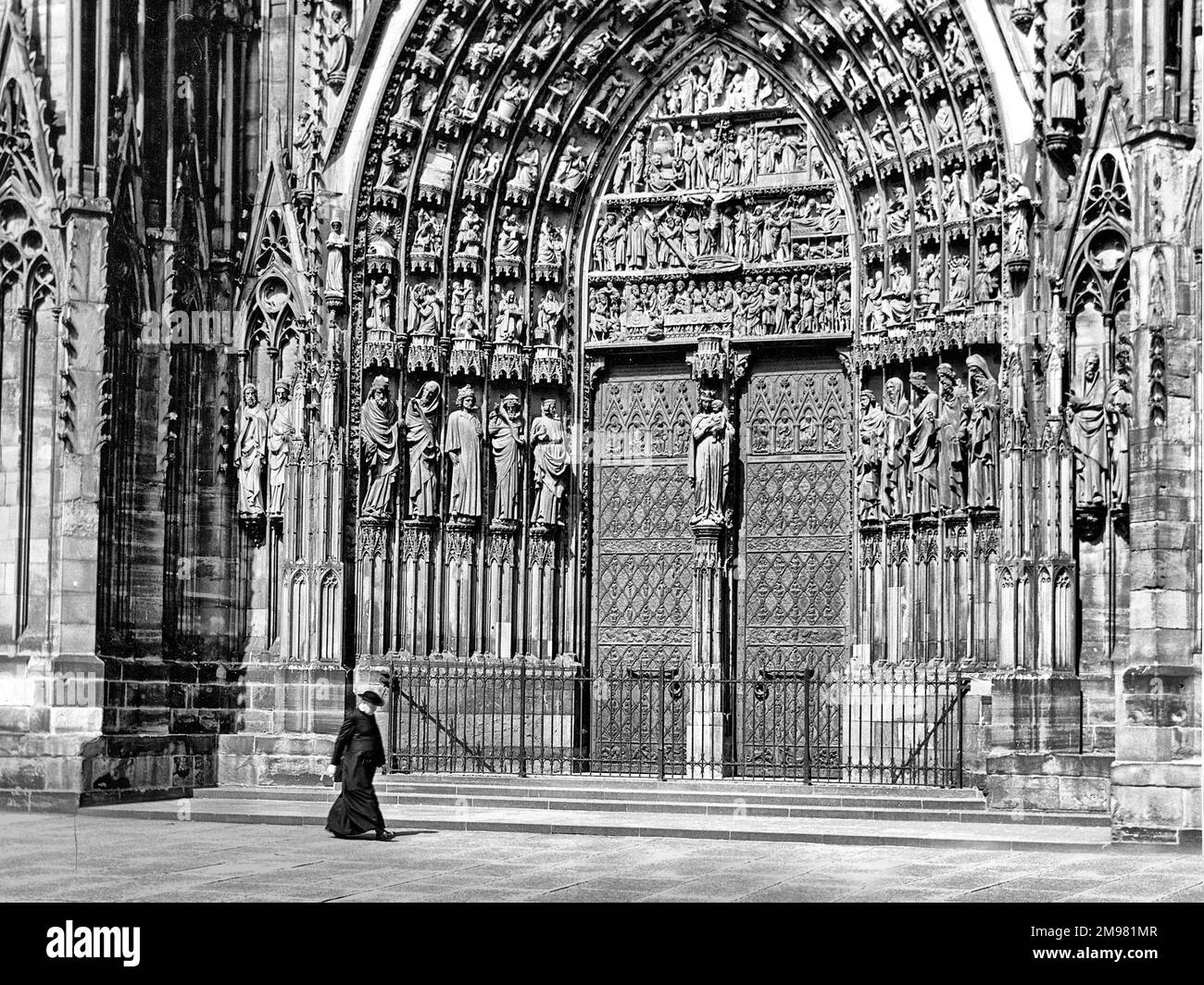 Sacerdote a piedi di fronte alla Cattedrale di Strasburgo, Francia. Foto Stock