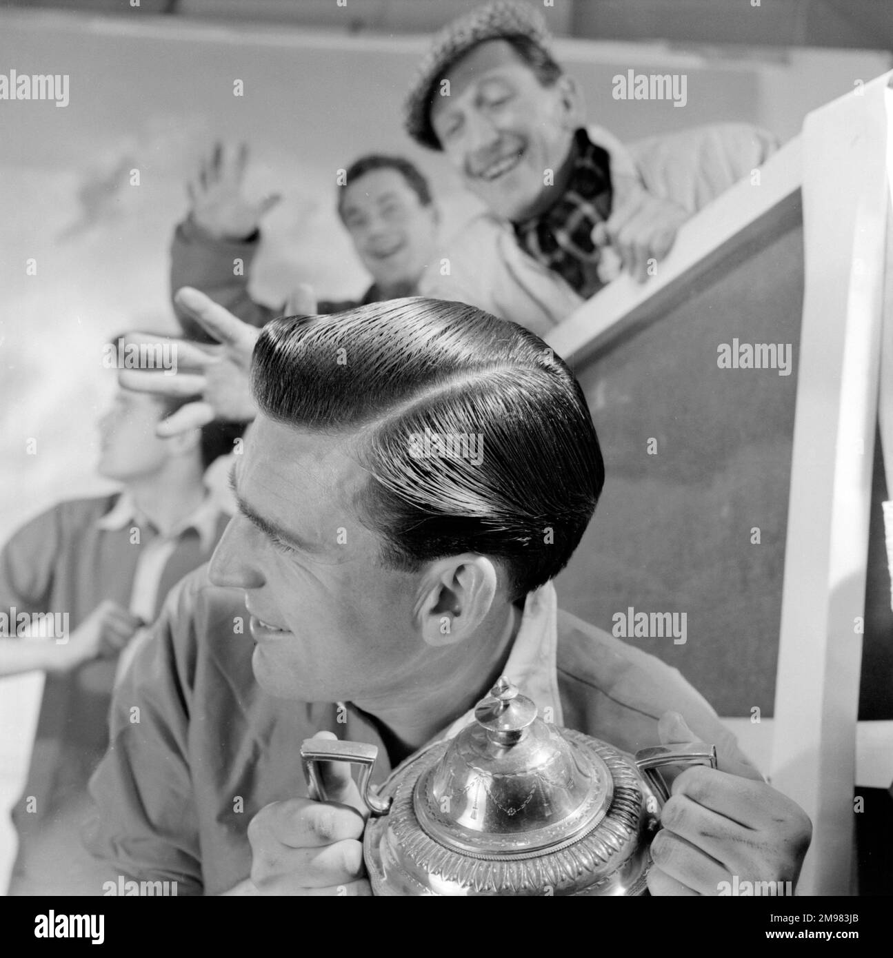 Pubblicità per i prodotti Silvikrin capelli -- tre modelli maschi (Derek Ufton, Alan Gore-Lewis e Ossie o'Leary) con un trofeo di calcio. Foto Stock