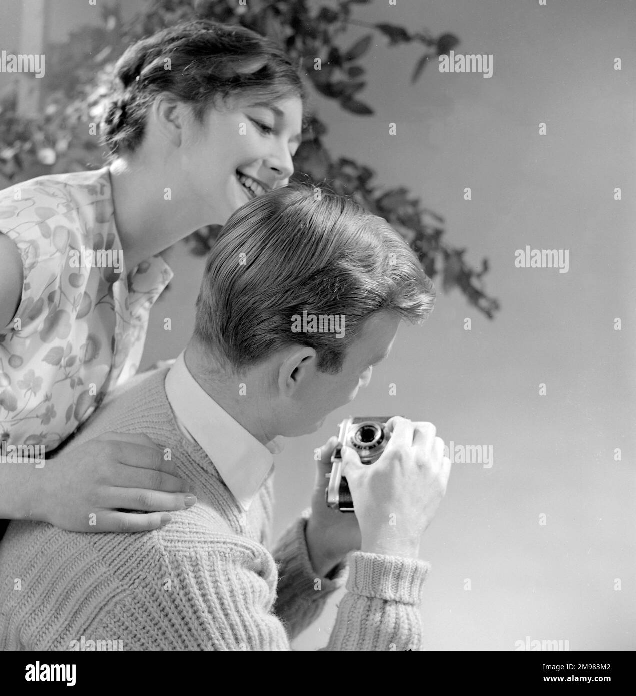 Pubblicità per i prodotti per capelli Silvikrin -- modelli maschili e femminili in posa con una macchina fotografica (Jeremy Dempster e Pam Rhodes). Foto Stock
