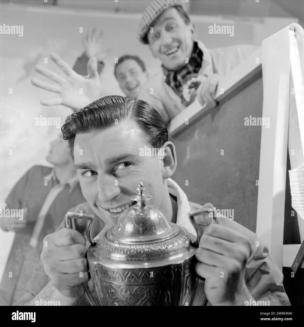 Pubblicità per i prodotti Silvikrin capelli -- tre modelli maschi (Derek Ufton, Alan Gore-Lewis e Ossie o'Leary) con un trofeo di calcio. Foto Stock