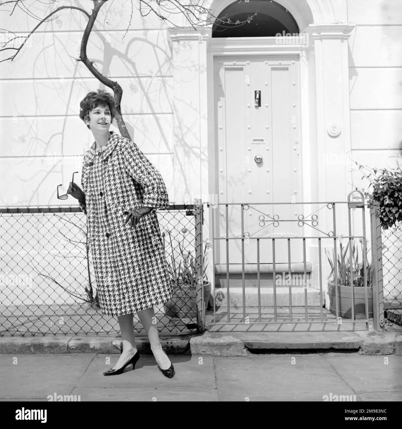 Pubblicità per Burberry cappotti -- modello femminile in posa fuori casa in stile georgiano. Foto Stock