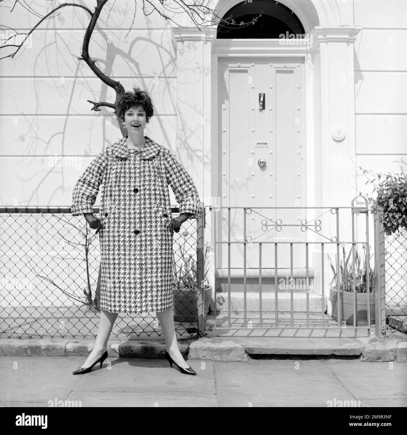 Pubblicità per Burberry cappotti -- modello femminile in posa fuori casa in stile georgiano. Foto Stock