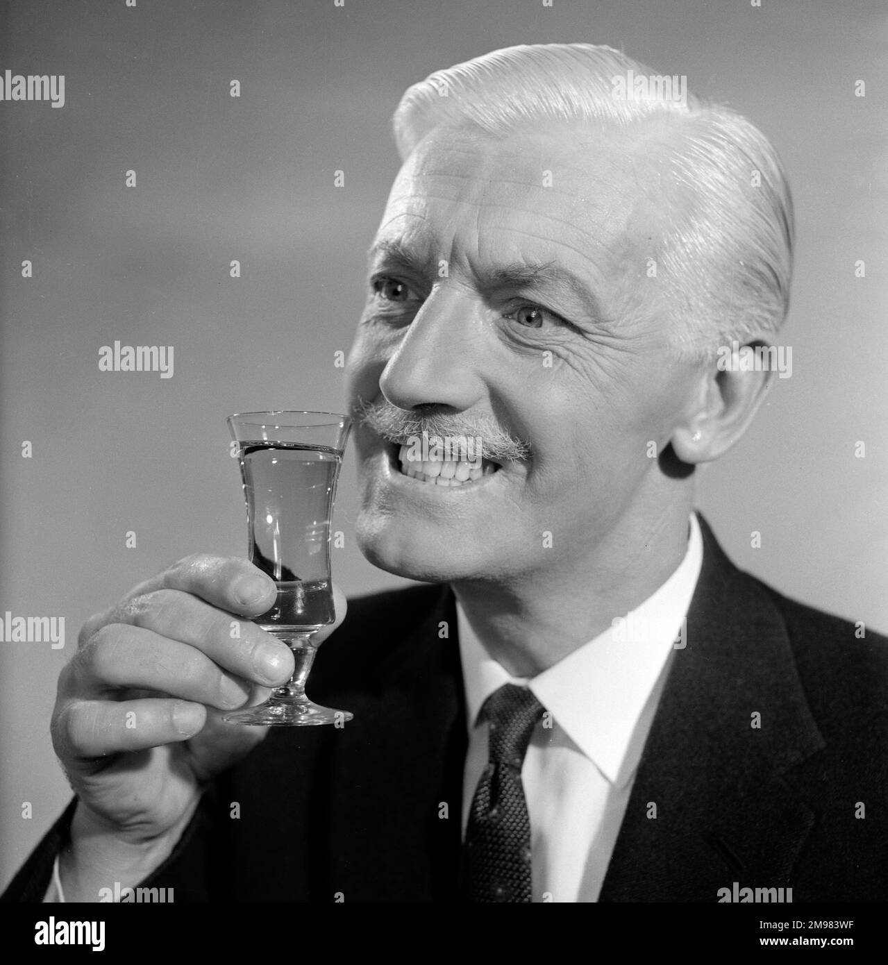 Pubblicità per lo sherry dell'emu -- modello maschio sorridente (George McGrath) che tiene su un vetro. Foto Stock