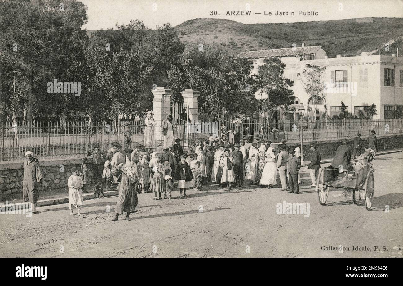 Arzew, Algeria - un gruppo di persone sta alla porta di un giardino pubblico recintato. Foto Stock