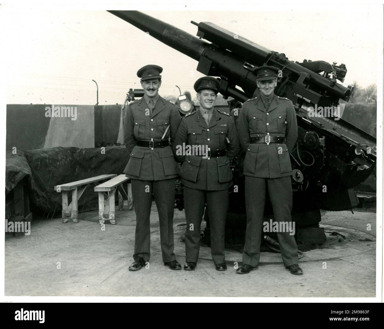 Tre membri Di Una truppa 281-88 in posa davanti a una pistola durante la seconda guerra mondiale. Foto Stock