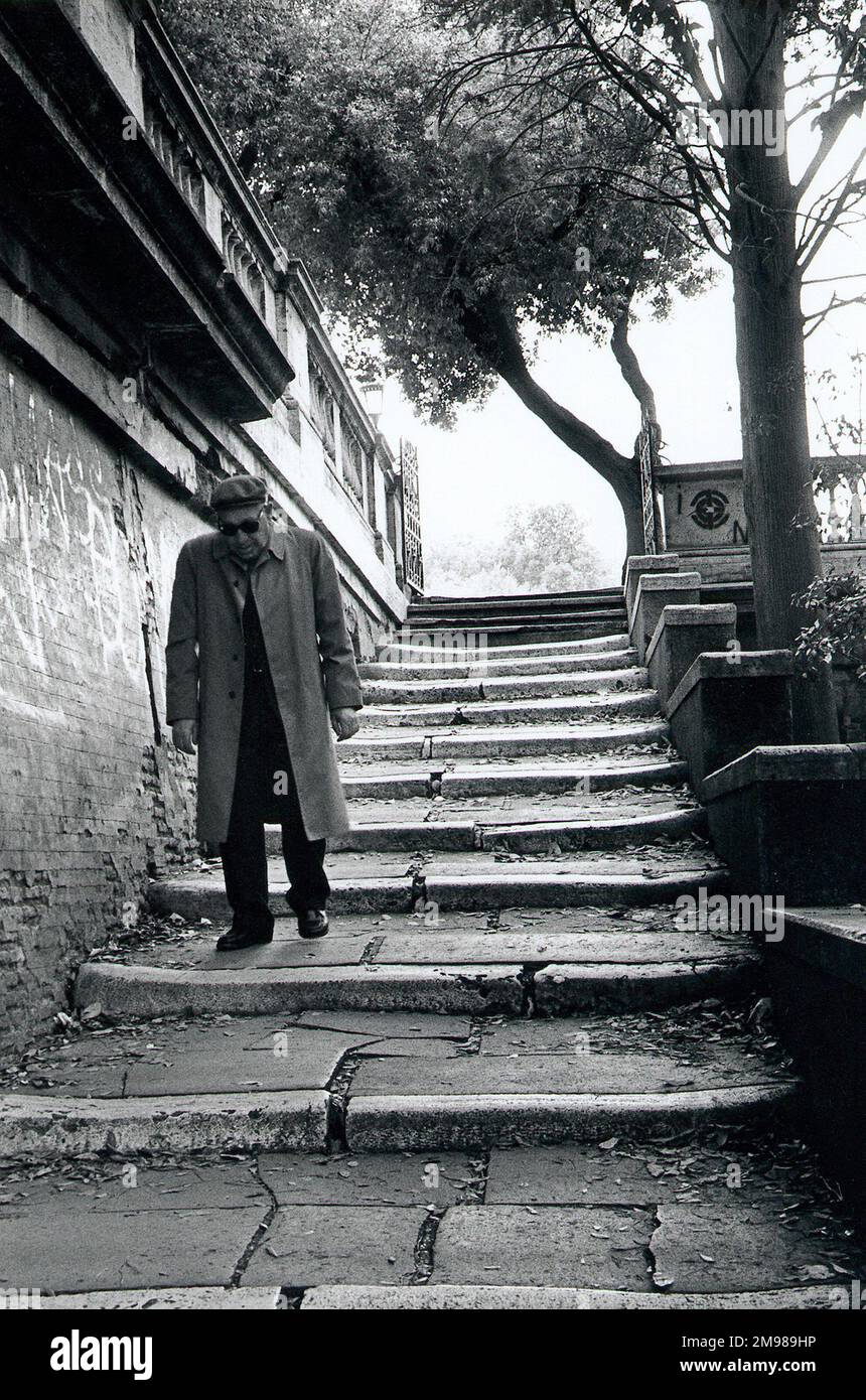 Uomo che cammina lungo una scalinata di pietra a Roma, Italia. Foto Stock
