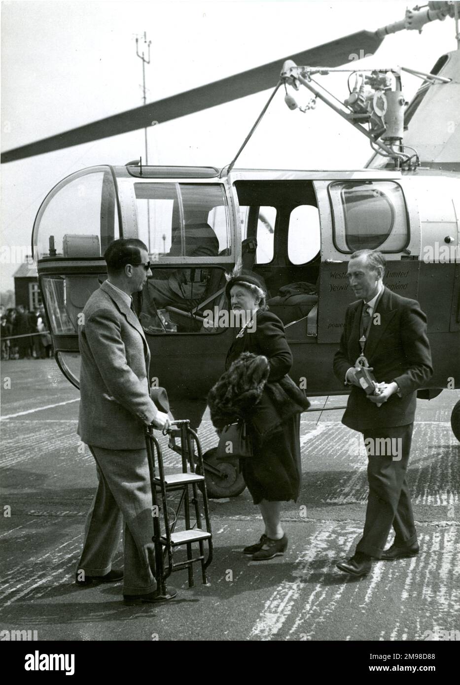 G.P. maggiore Bulman, CBE, FRAeS, presidente della Royal Aeronautical Society 1950-1951 e sua moglie arrivano al 1951 Royal Aeronautical Society Garden Party presso il White Waltham Aerodromo il 6 maggio da un Westland S51 volato da D. Colvin. Foto Stock