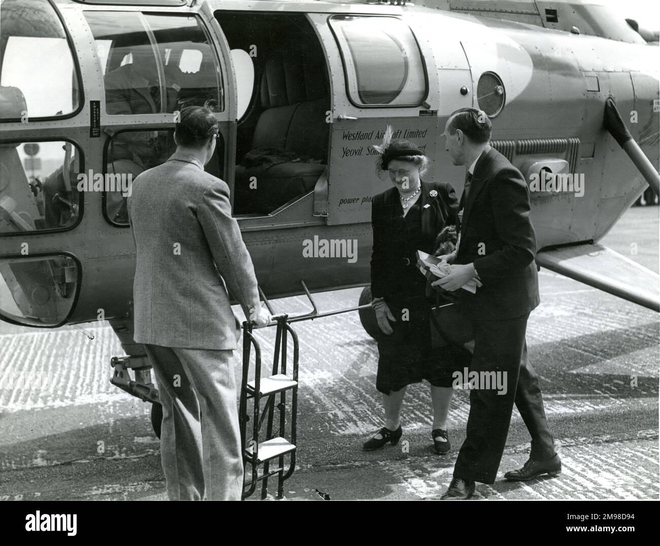 G.P. maggiore Bulman, CBE, FRAeS, presidente della Royal Aeronautical Society 1950-1951 e sua moglie arrivano al 1951 Royal Aeronautical Society Garden Party presso il White Waltham Aerodromo il 6 maggio da un Westland S51 volato da D. Colvin. Foto Stock