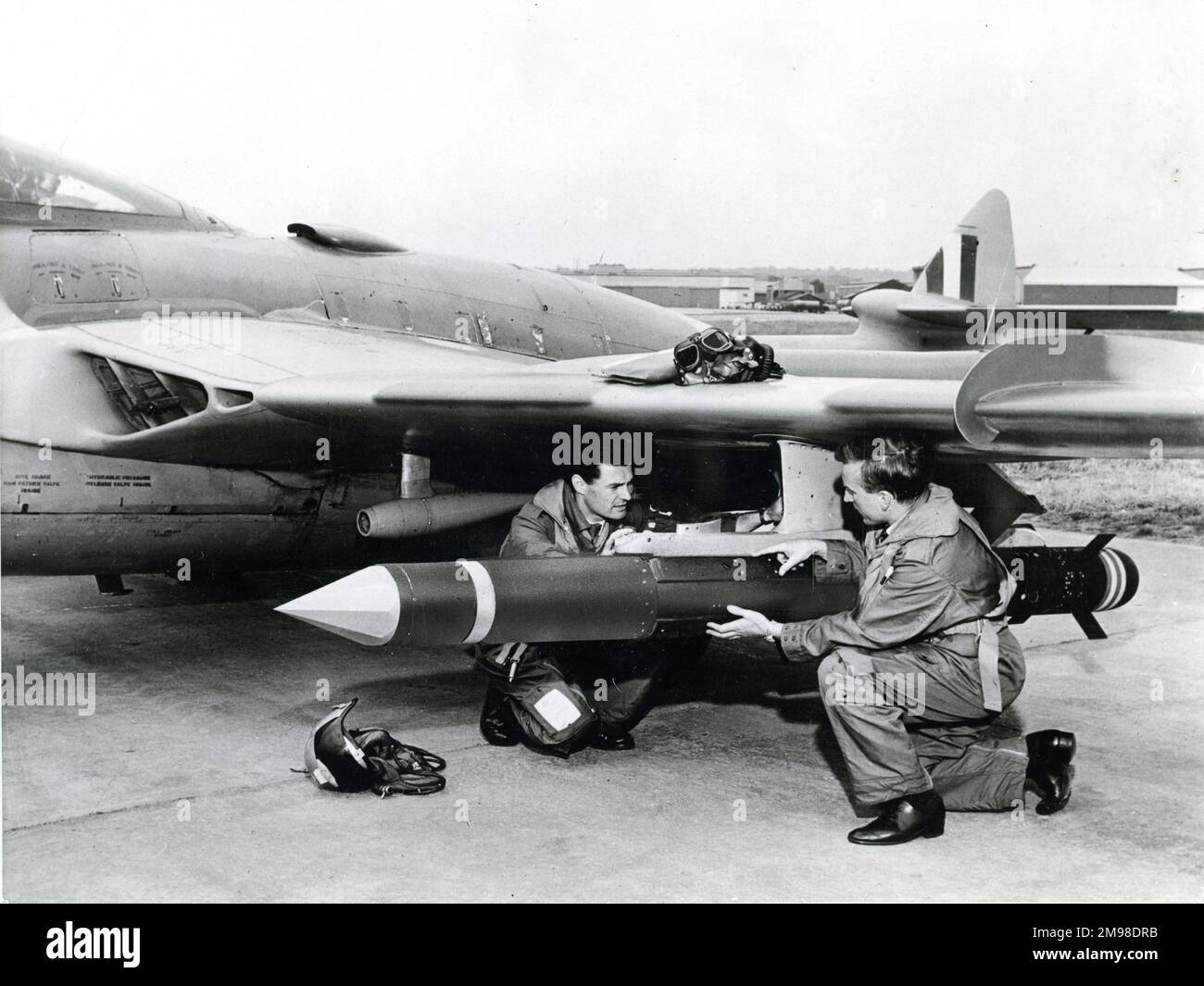 Il pilota e il navigatore effettuano i controlli finali di un missile aria-aria de Havilland Firestreak su una de Havilland Venom a Hatfield prima di sparare l'arma sul campo di prova ad Aberporth. Foto Stock