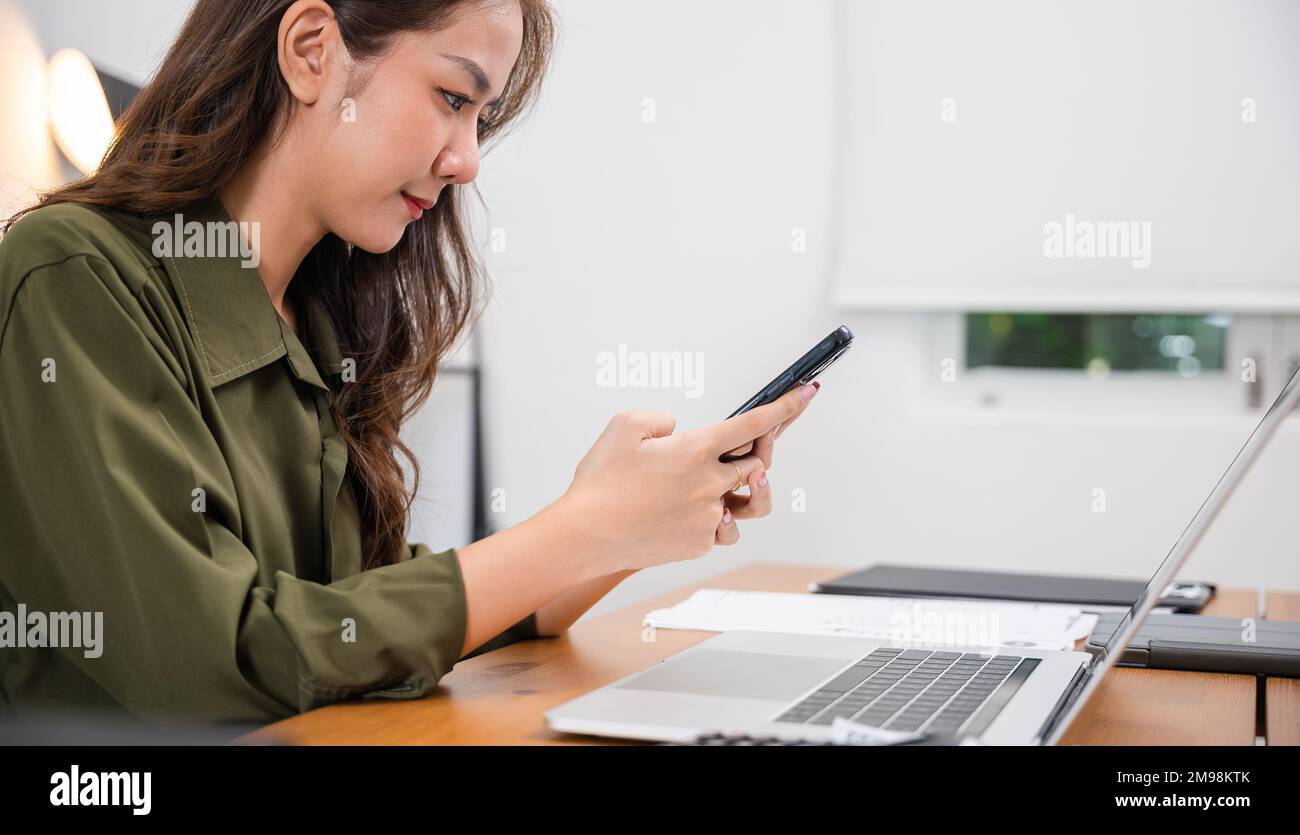 La giovane donna asiatica paga per il successo del pagamento digitale delle merci su smartphone Foto Stock