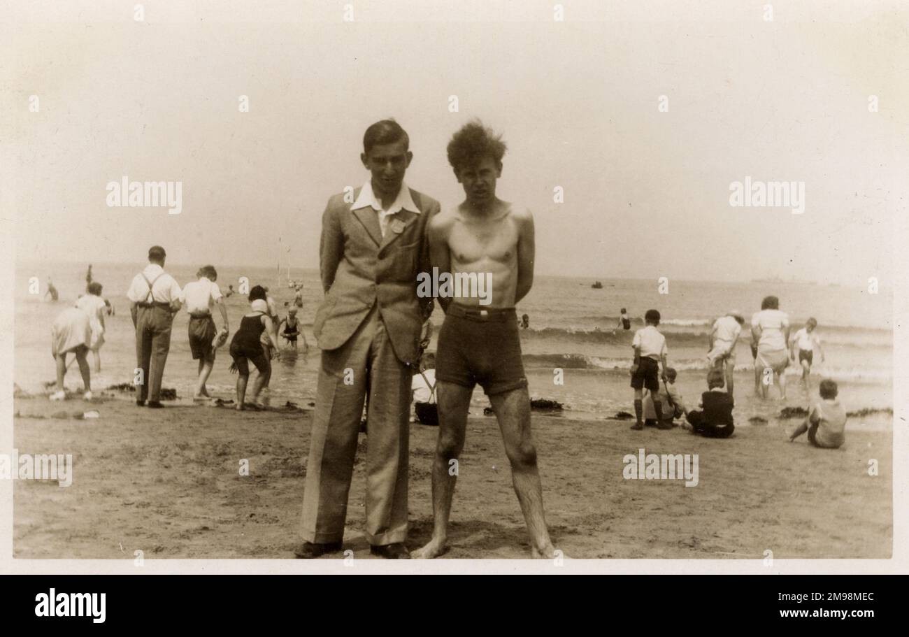 Due fratelli (uno che mostra più di una tenacia per fare un tuffo) a tan unnamed stazione balneare britannica. Foto Stock