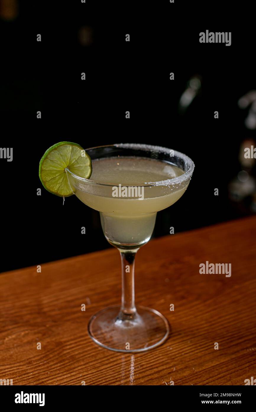 Un bicchiere di daiquiri classico con lime su un bancone bar Foto Stock