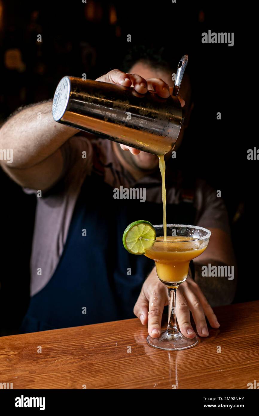 Un barista che mescola i daiquiri usando uno shaker da cocktail Foto Stock