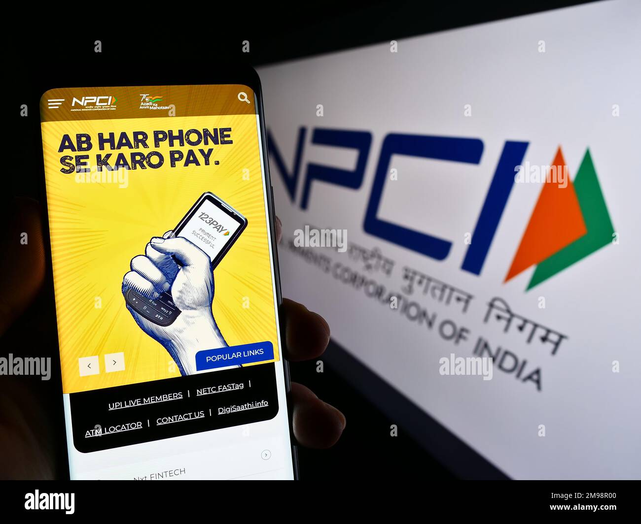 Persona che tiene il cellulare con il sito web della National Payments Corporation of India (NPCI) sullo schermo con il logo. Messa a fuoco al centro del display del telefono. Foto Stock