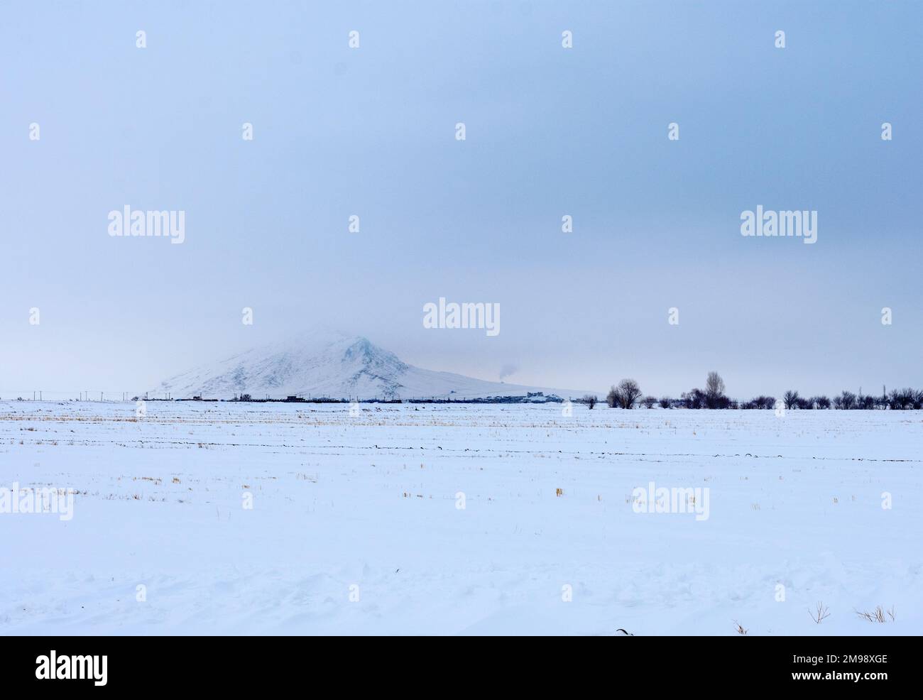 una montagna in nebbia e neve Foto Stock
