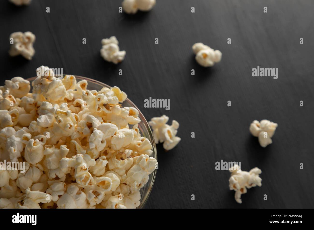 Ciotola di popcorn su una base di legno nero e copia di expacio Foto Stock