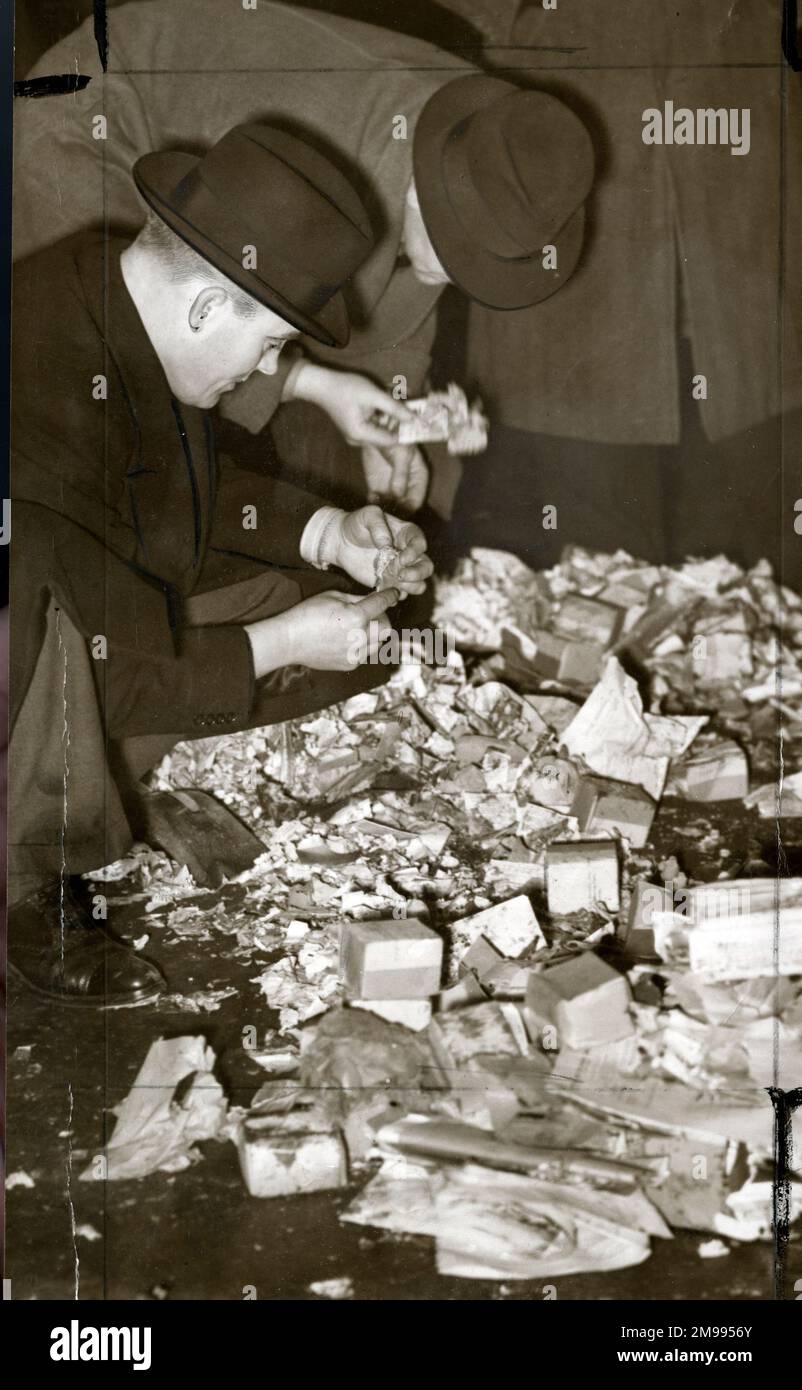Polizia alla ricerca di detriti dopo le bombe nascoste in buste esplose a Euston Station, Londra, 6 febbraio 1940. Foto Stock