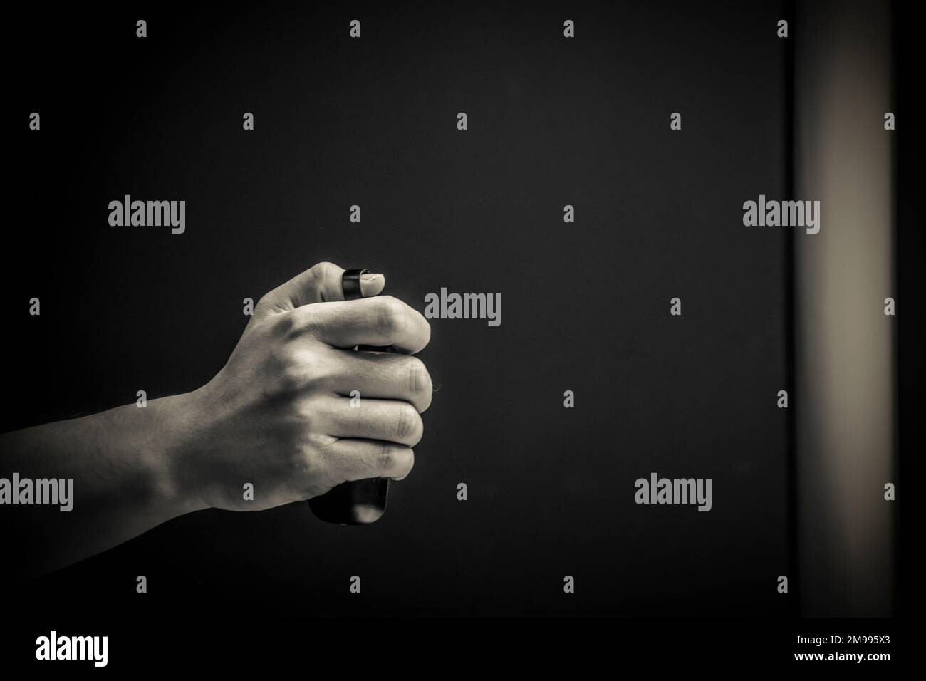 Una mano maschio con un telecomando in bianco e nero Foto Stock