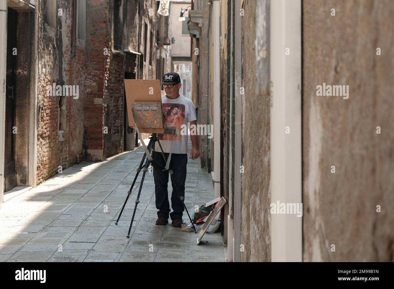 Artista in una piccola strada secondaria a Venezia Foto Stock