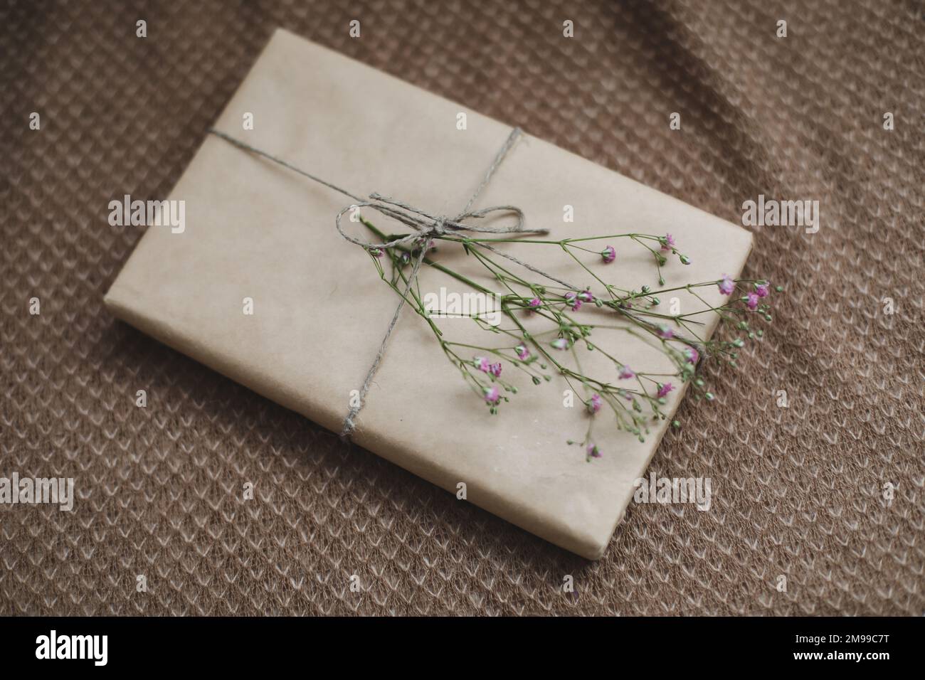 una scatola regalo in carta artigianale decorata con un fiore Foto Stock