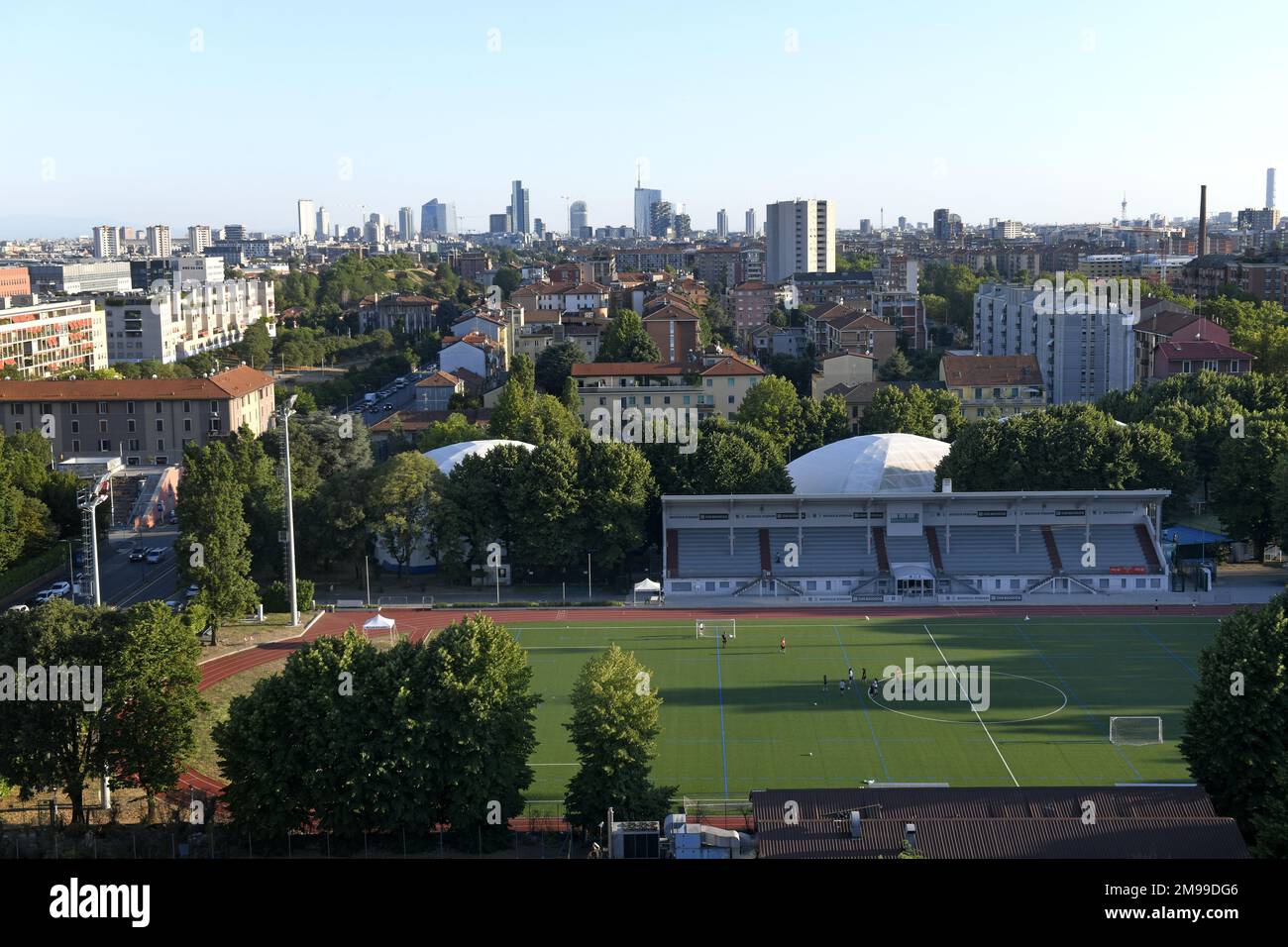 Vista dall'alto dello stadio di calcio di un sobborgo con lo skyline di Milano sullo sfondo Foto Stock