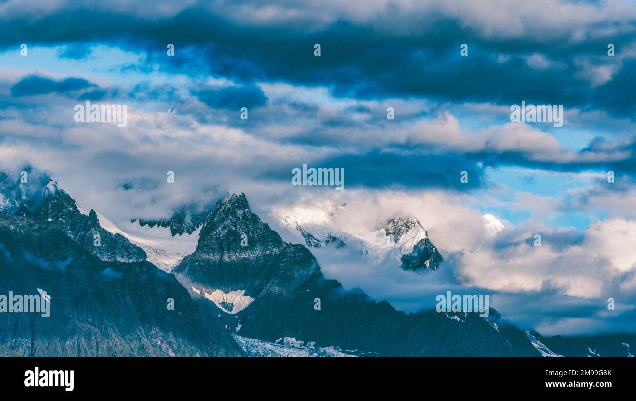 Uno splendido scenario di Meili neve montagna con le nuvole nella contea di Deqen, provincia di Yunnan, Cina Foto Stock