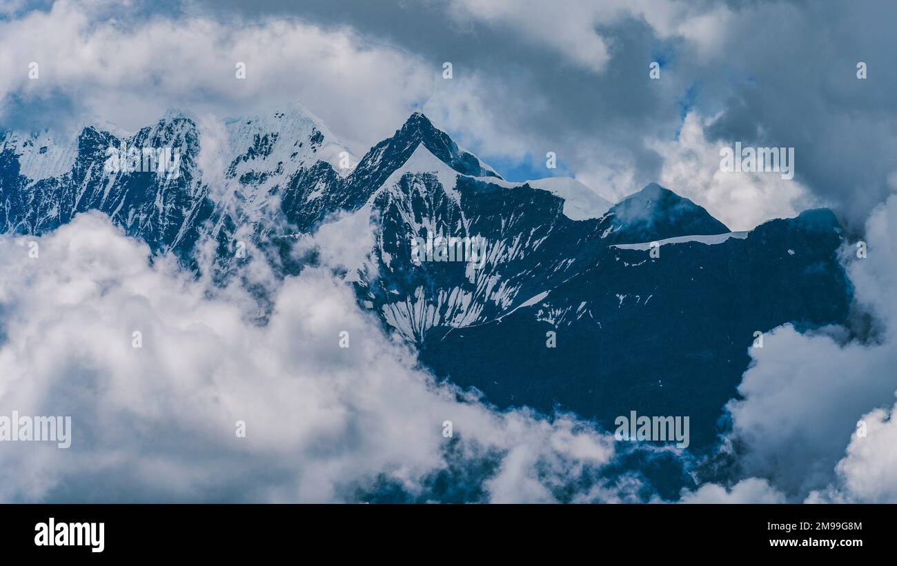 Uno splendido scenario di Meili neve montagna con le nuvole nella contea di Deqen, provincia di Yunnan, Cina Foto Stock