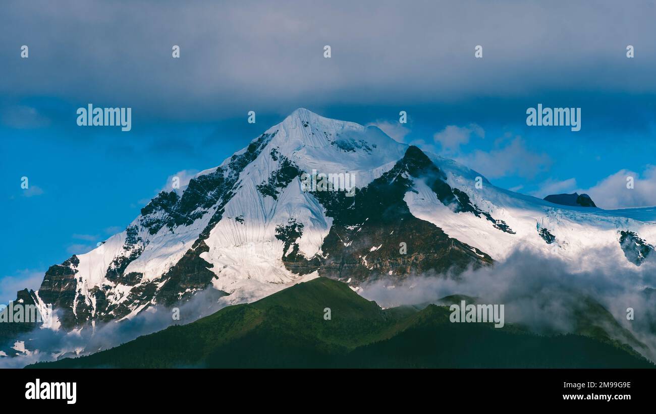 Uno splendido scenario di Meili neve montagna con le nuvole nella contea di Deqen, provincia di Yunnan, Cina Foto Stock