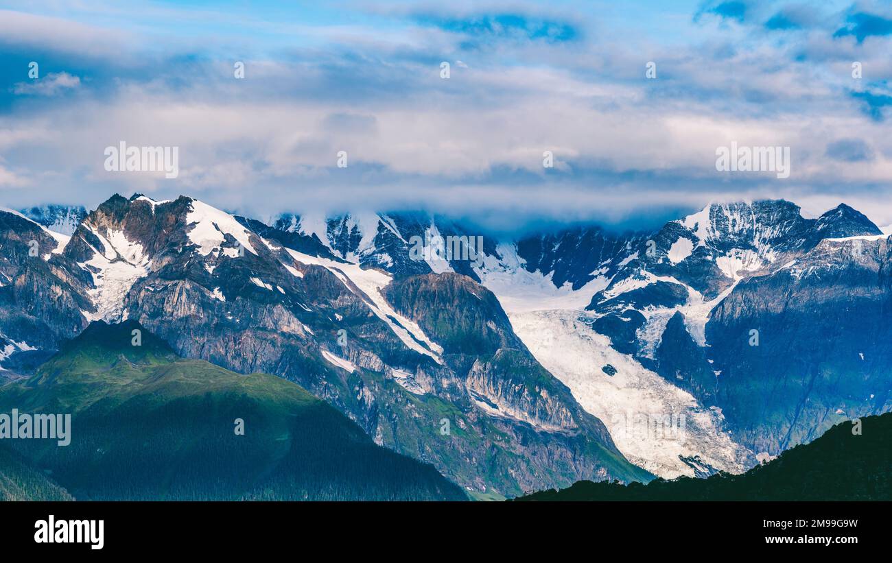 Uno splendido scenario di Meili neve montagna con le nuvole nella contea di Deqen, provincia di Yunnan, Cina Foto Stock