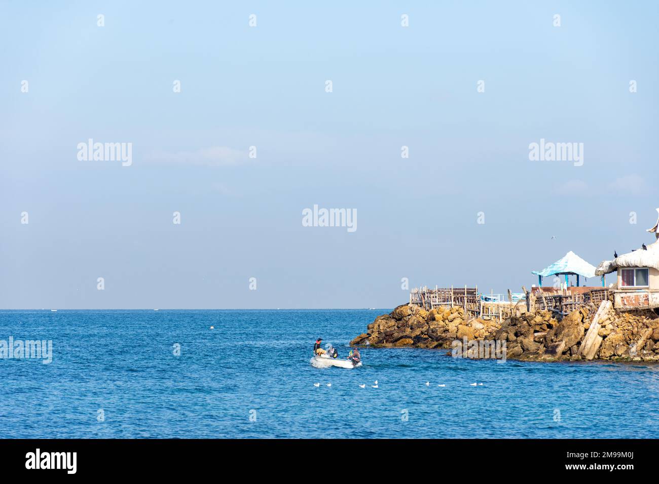 Pescatore su una barca da pesca in legno sul Mar Mediterraneo. Foto Stock