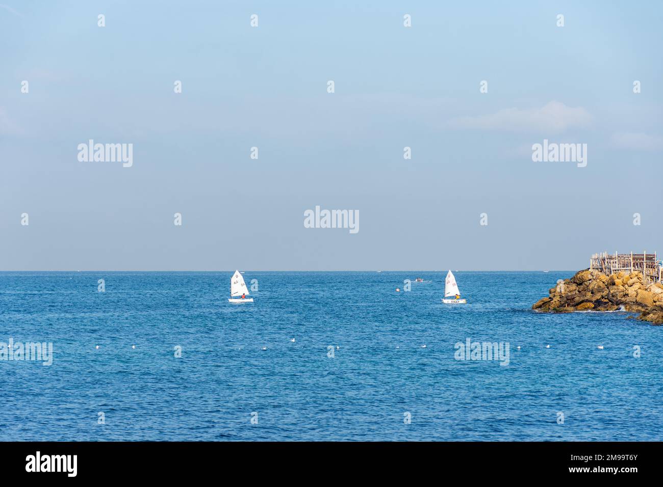 Due barche a vela sul blu del Mediterraneo nella città di Algeri. Sport acquatici. Foto Stock