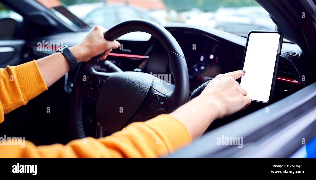 Primo piano del conducente con l'unità vivavoce per telefono cellulare montata sul cruscotto Foto Stock