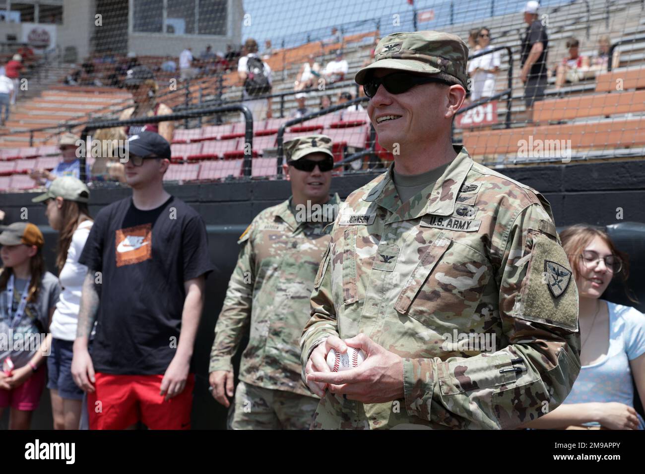Michael Johnson, comandante della Brigata dell'Aviazione 110th, aspetta vicino al dugout prima di buttare fuori il primo campo cerimoniale durante una partita di baseball dell'università a Troy University, Troy, Alabama, 15 maggio 2022. Foto Stock