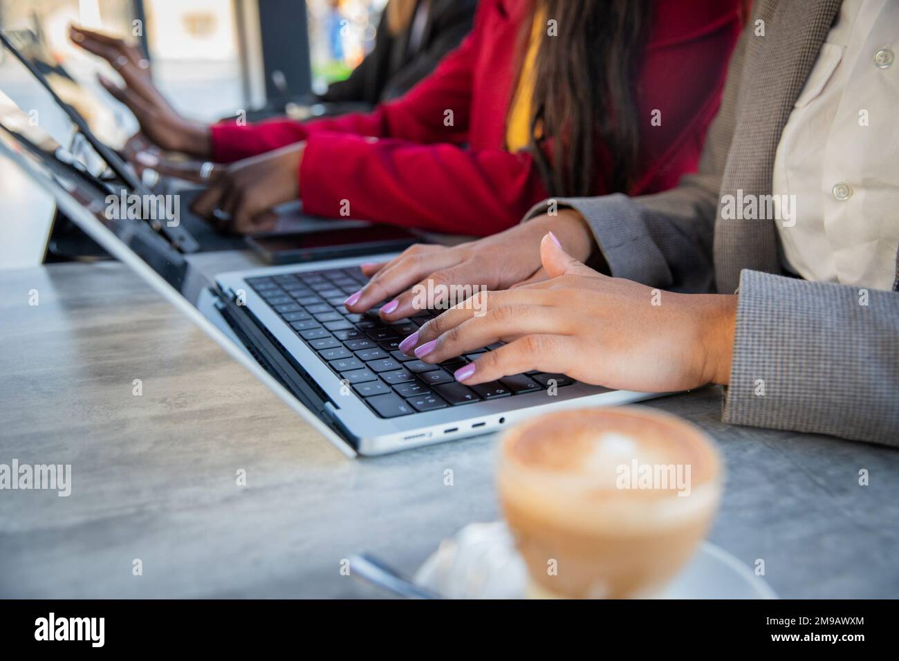 Primo piano delle mani femminili che lavorano con computer portatili e tablet in ufficio, delle lavoratrici Foto Stock