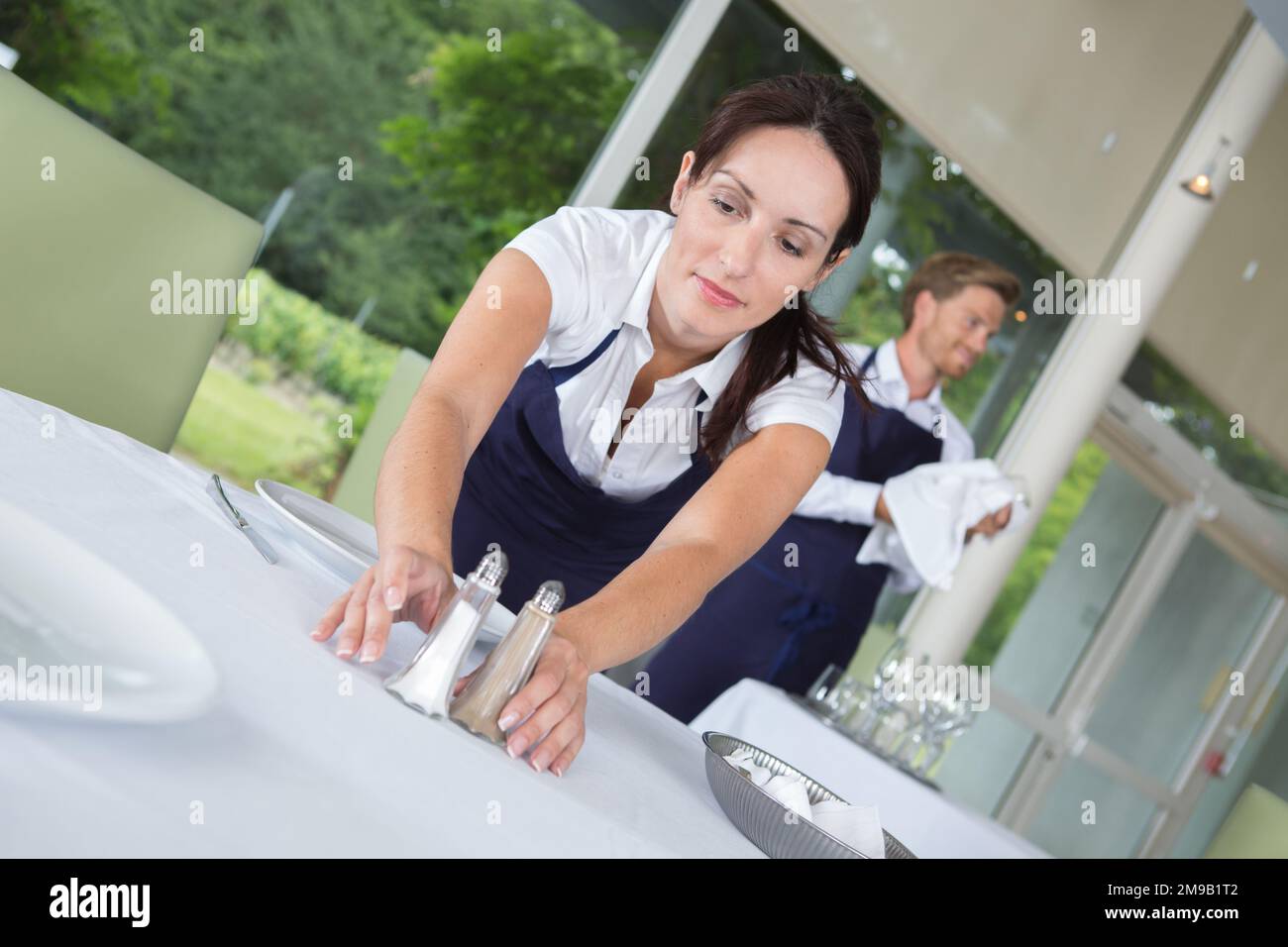 ritratto di donna che allestiscono tavolo Foto Stock