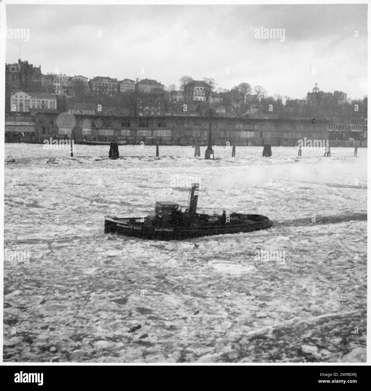 Un rimorchiatore che naviga attraverso acque ghiacciate a St Pauli, Amburgo, Germania nel febbraio 1946 Foto Stock