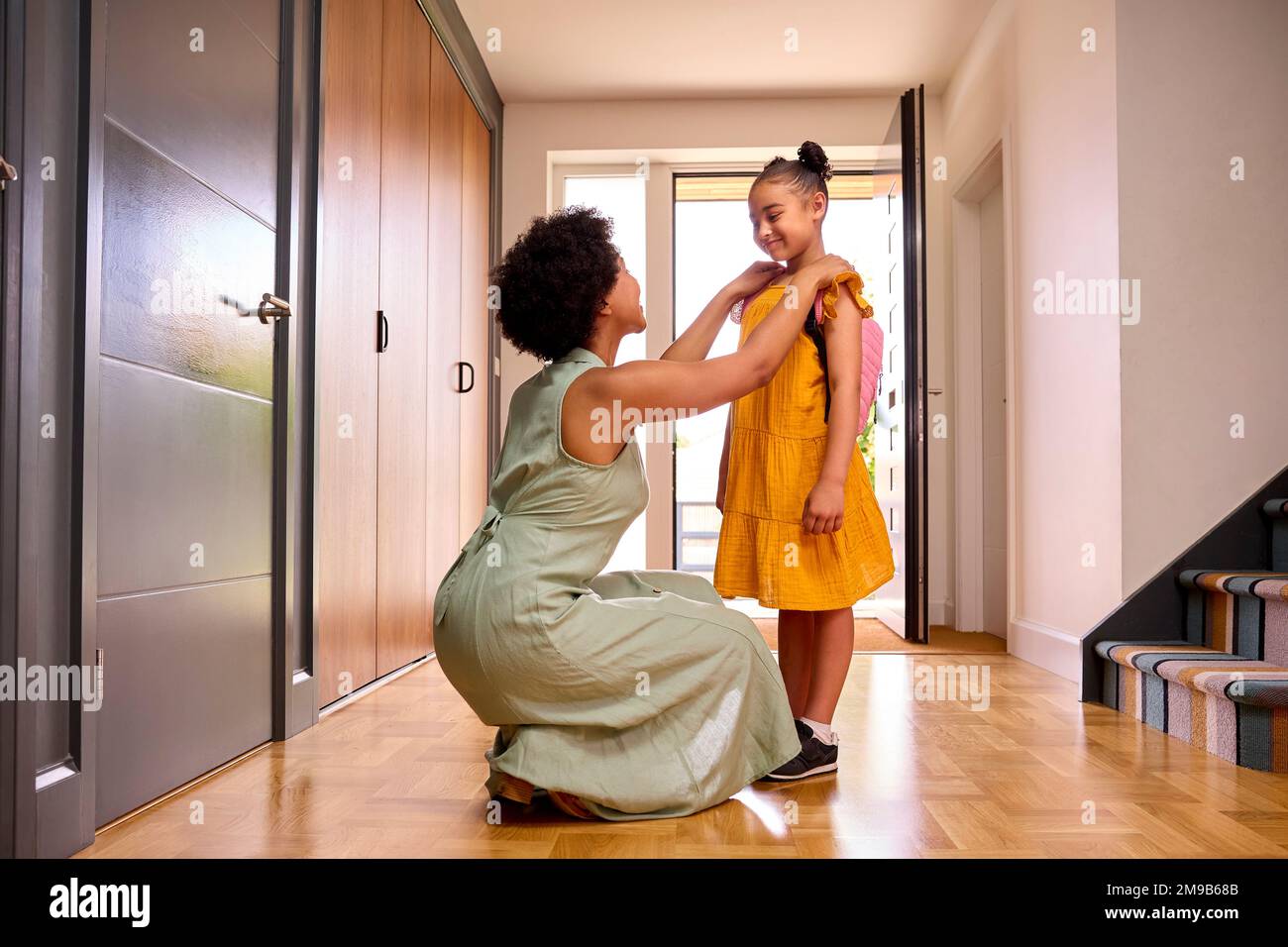 Madre a casa aiutare figlia prepararsi per andare a scuola Foto Stock
