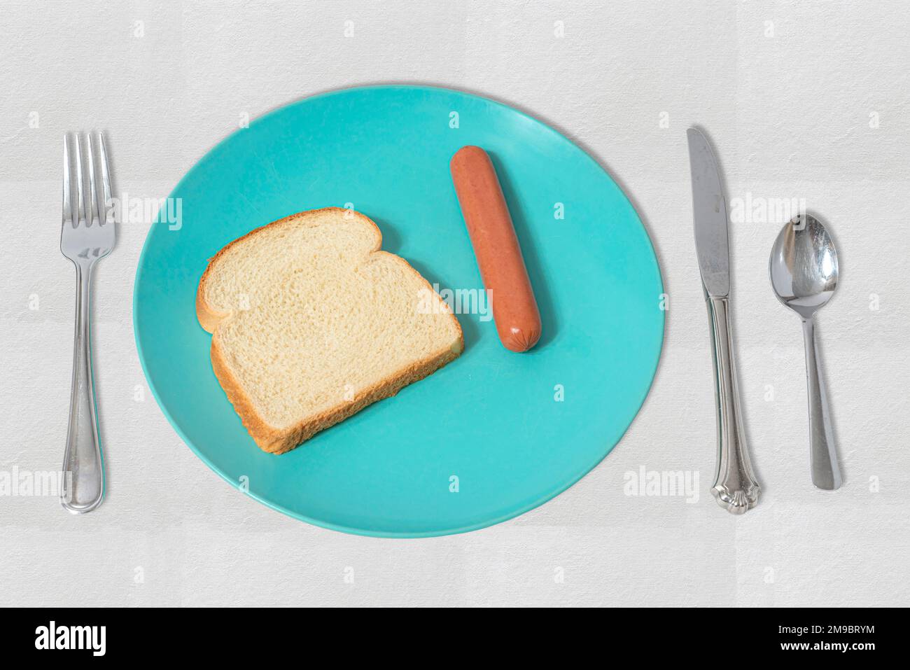 Una semplice illustrazione con un hot dog e una fetta di pane. Ciò fornisce un'illustrazione visiva dell'effetto dei prezzi elevati dei prodotti alimentari sui poveri. Foto Stock