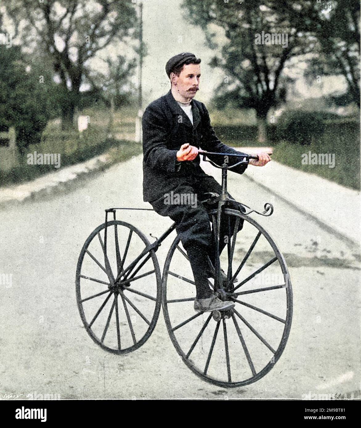 Un ciclista su una bicicletta 'Bone Shaker' del 1840s a 1850s. Questo tipo di bicicletta è stato innovativo nel avere pedali, ma ha guadagnato il suo moniker attraverso l'uso di ruote in legno massiccio o metallo. Foto Stock