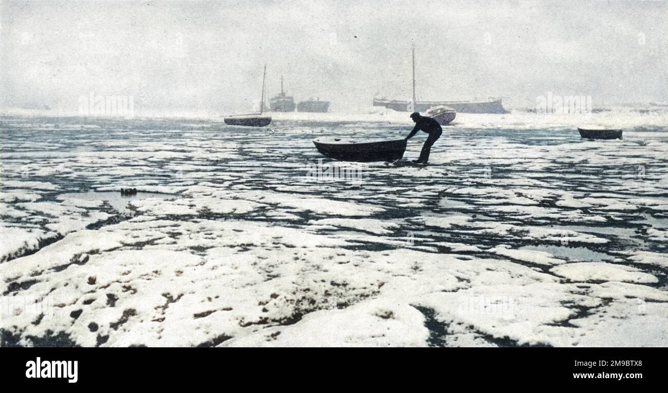Una scena durante il grande congelamento del 1947, uno degli inverni più duri conosciuti in Gran Bretagna. A Leigh-on-Sea in Essex, un barcaiolo viene raffigurato salvando il suo gommone dal ghiaccio circostante che fa sembrare l'estuario del Tamigi più simile a un paesaggio polare. Solo spostando la propria imbarcazione ogni ventiquattro ore, i proprietari di imbarcazioni potrebbero sperare di evitare i danni causati dalla pressione del ghiaccio. Foto Stock