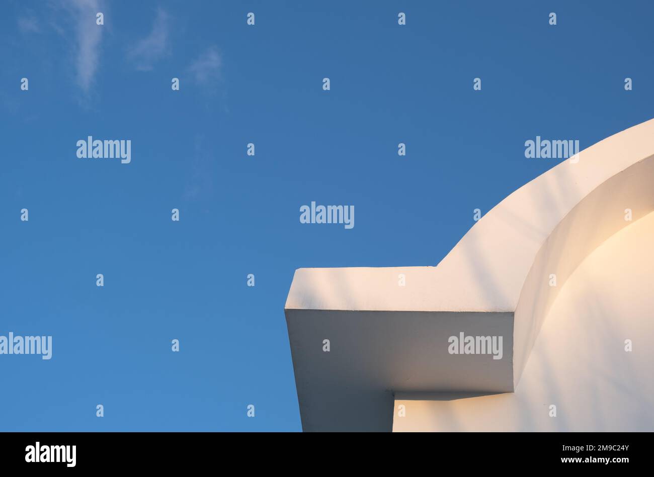 Tetto curvo bianco dell'edificio contro il cielo blu. Simmetria minima dell'architettura Foto Stock