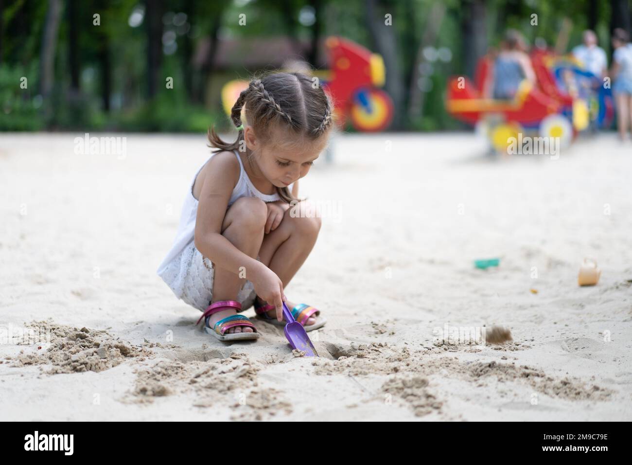 Bambina giocare Sandbox Parco giochi Digging sabbia Shovel