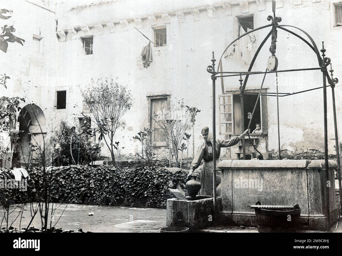 Donna portoghese che attingeva acqua da un pozzo antico, York House, Lisbona, Portogallo Foto Stock