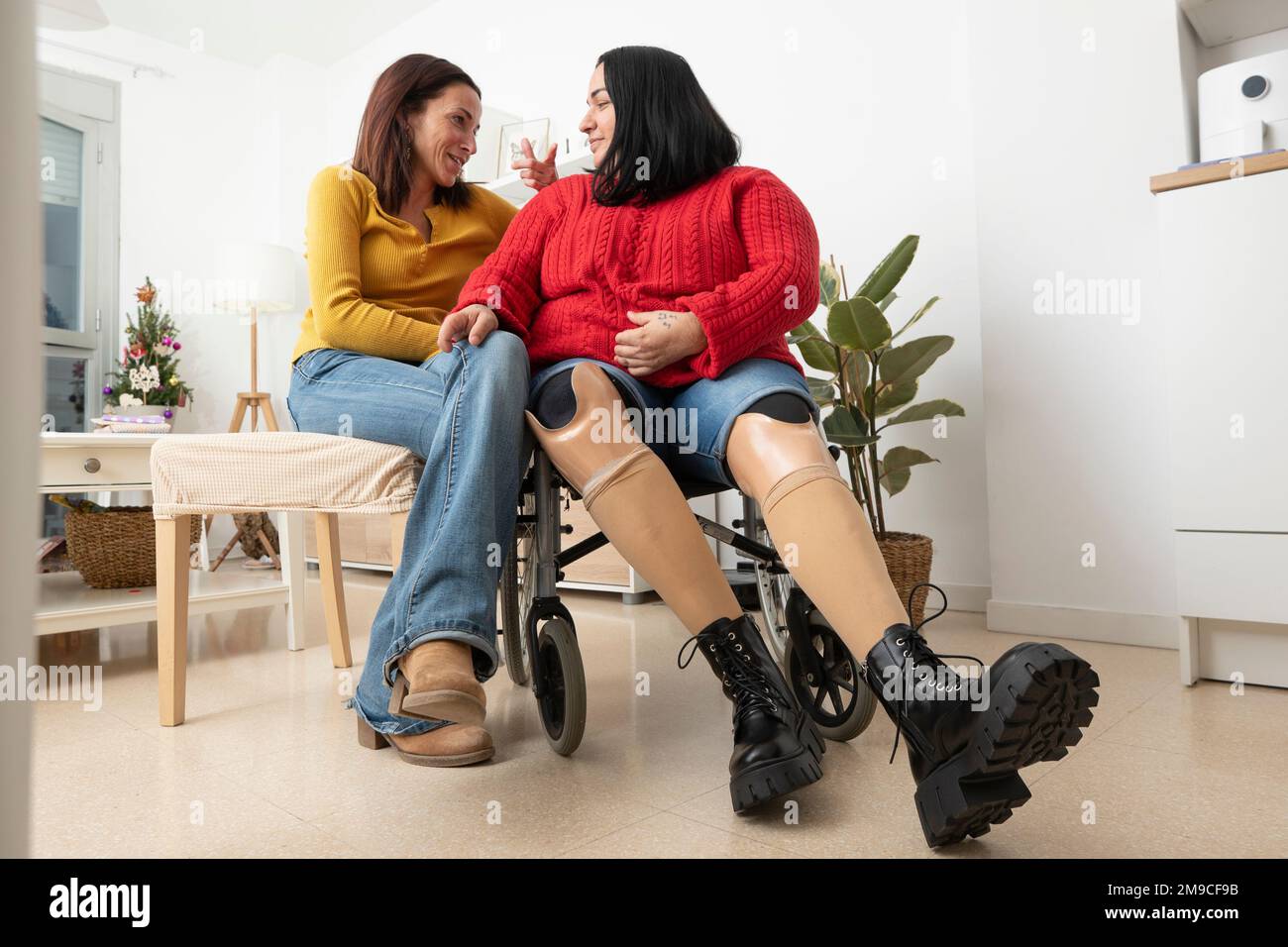Due donne diverse che chiacchierano casualmente a casa. Foto Stock