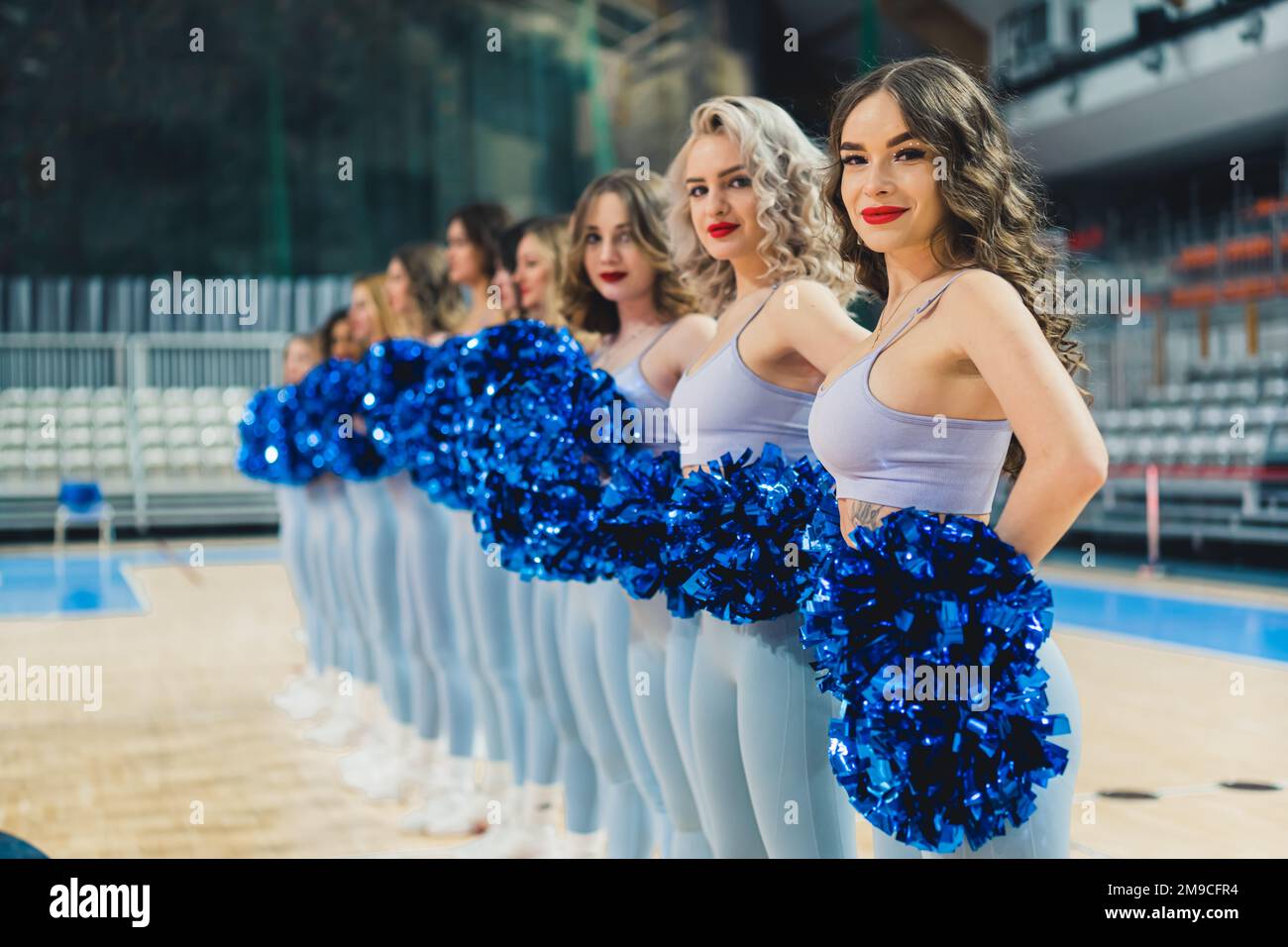 Scatto medio di una squadra cheerleading in fila in abiti coordinati. Concetto sportivo. Foto di alta qualità Foto Stock