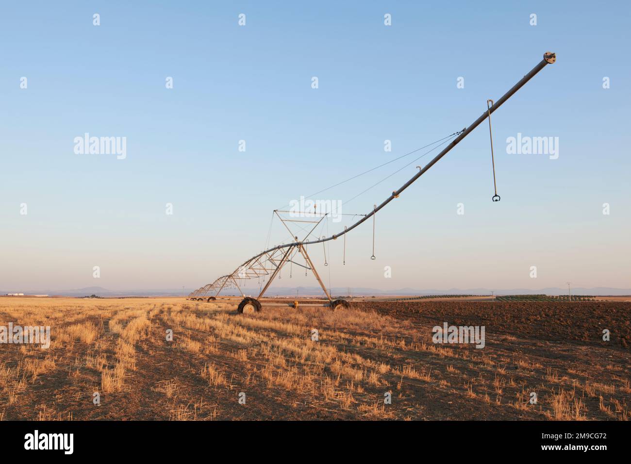 Sistema di irrigazione in campo al tramonto in campo. Toledo, Spagna Foto Stock